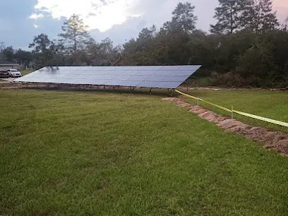 Ground-mounted solar array at the far edge of a wide grassy field