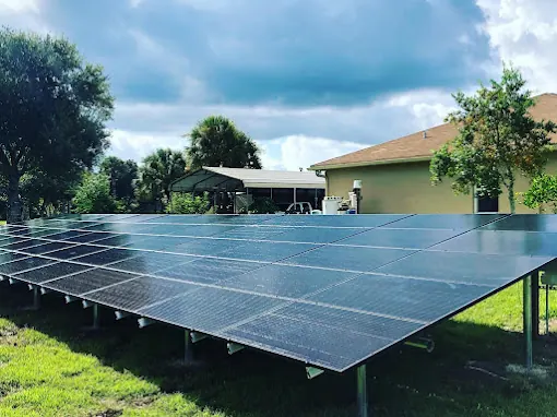 Ground-mounted solar array on a lawn beside a single-storey house