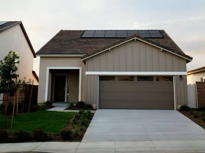 Beige suburban house with a garage and solar panels on the roof